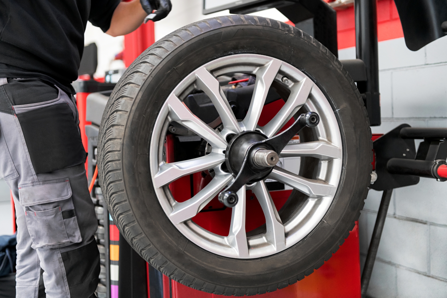 Technician performing tire rotation on a car at DriveTime Automotive in Salem, OR.